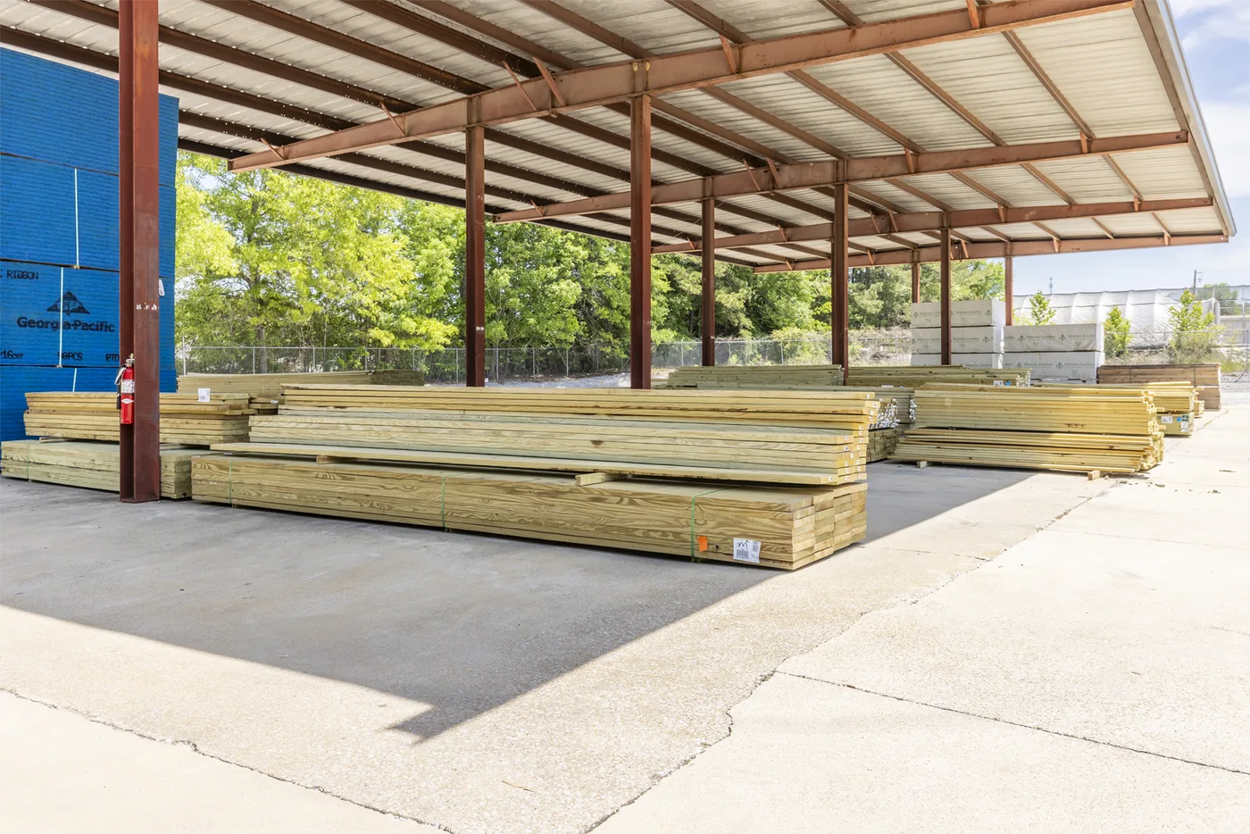 Stacks of lumber under Etowah Builders Supply's covered yard